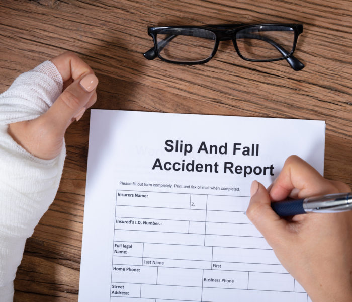 An Overhead View Of Woman With Factured Hand Filling The Slip And Fall Injury Report